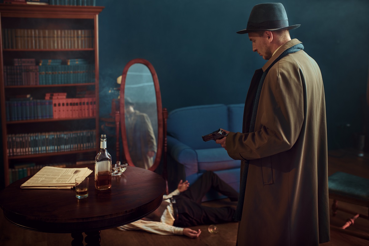 Male detective with gun standing at the mirror