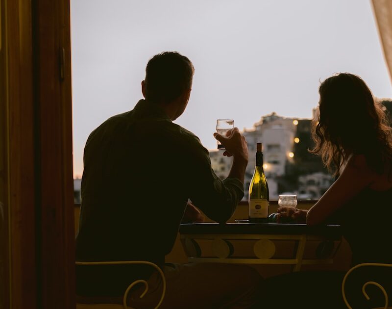 man and woman sitting on chair in front of table during sunset