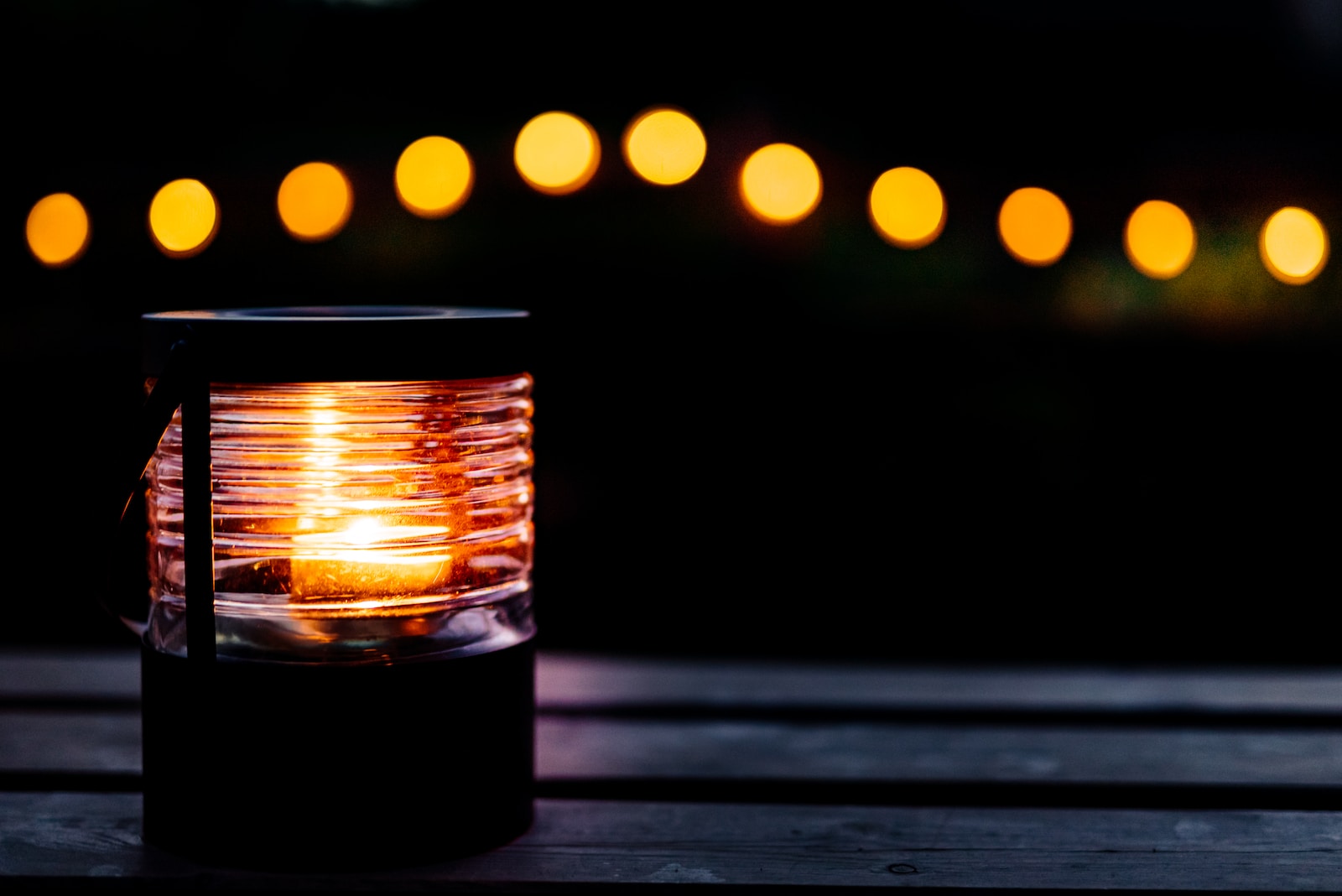 a lantern is sitting on a table with lights in the background