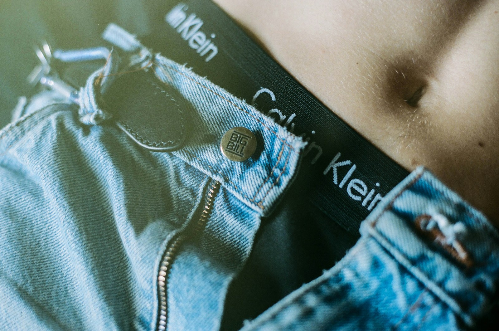 a close up of a person's stomach wearing a pair of jeans